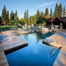 Outdoor pool complex surrounded by evergreen trees